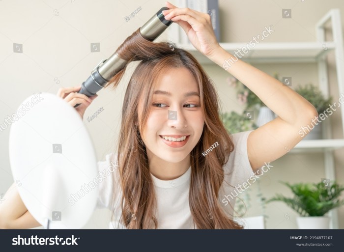 Asian Woman Using Curling Iron Curling Hair. Hairstyle and Hairdressing Isolate on White ... Asian Woman Using Curling Iron Curling Hair. Hairstyle and Hairdressing Isolate on White ...